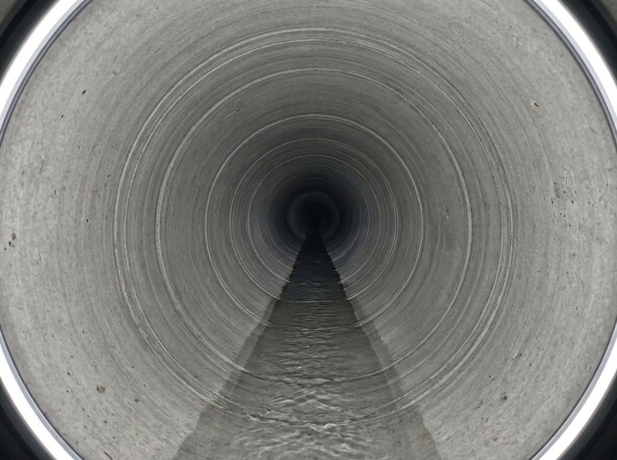 Sewer camera view of the same Buda under-slab main after cleaning and re-grading, showing clean walls and free flow